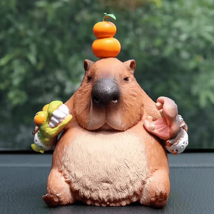 Silicone mold of seated capybara with stacked oranges on head, holding fruit in both hands, eyes gently closed


