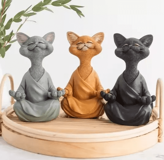 Three meditating cat figures with closed eyes and folded robes, made using white silicone mold for resin or candle making