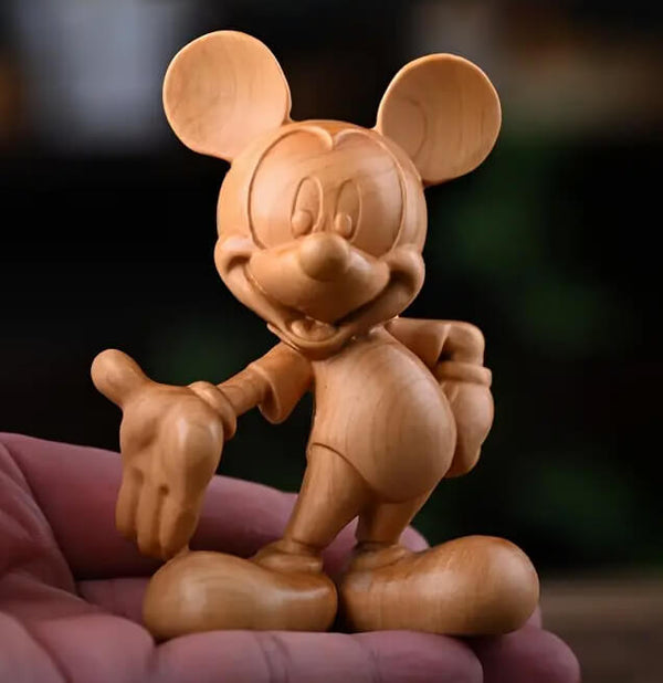 Cartoon-style standing mouse resin figure with large ears and smiling expression, posed on pink cushion

