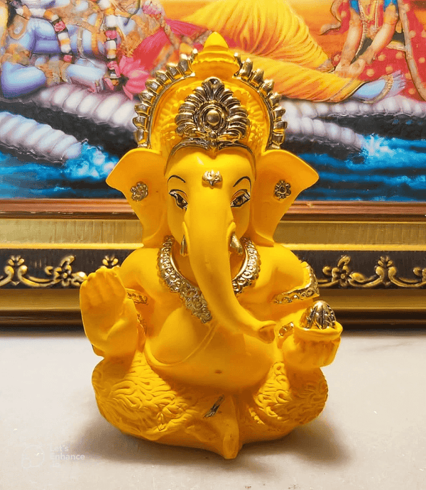 Yellow resin casting of Lord Ganesha in seated pose with crown and raised hand, created using silicone mold for candle and soap making