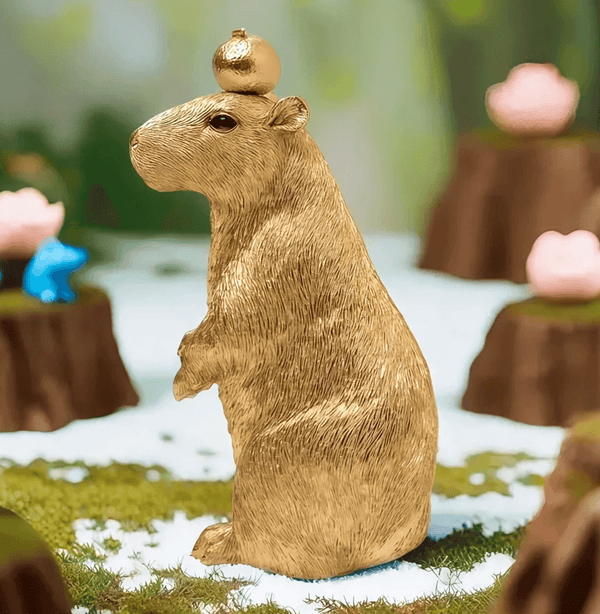 Making a seated capybara figure with an apple on its head using white silicone mold for candle or resin casting