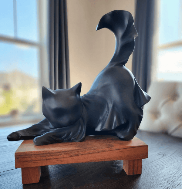 Black ghost cat sculpture in stretching pose with flowing drape form and curled tail, made using white silicone mold for resin or candle making