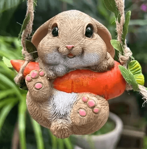 Cute bunny figure sitting upright and holding carrot, made using silicone mold with rounded shape and long ears


