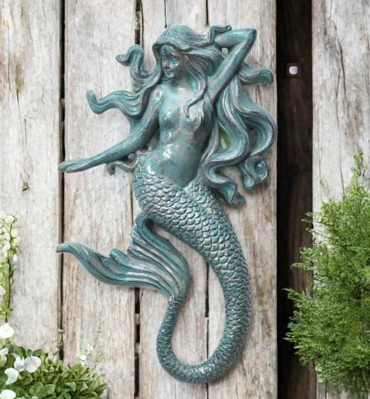 Wall-mounted mermaid figure with long flowing hair and curled tail, created using silicone mold for nautical décor


